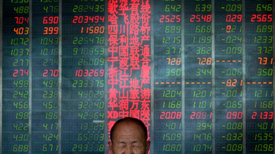 Investidor reage em frente de um painel eletrônico que mostra informações sobre ações em uma corretora em Taiyuan, na China