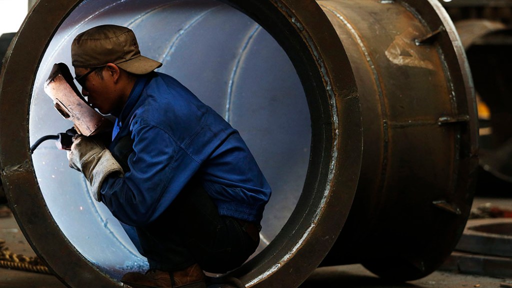 Funcionário solda uma turbina de água em uma fábrica em Jinhua, província de Zhejiang, na China