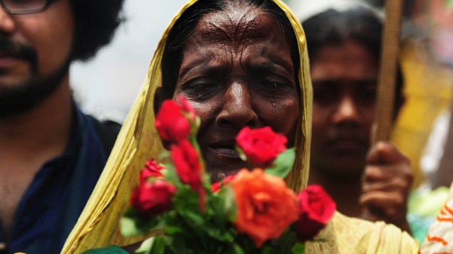 Um membro da família de um trabalhador da fábrica têxtil chora quando presta homenagem às vítimas do desabamento do prédio de nove andares em Savar, nos arredores de Dhaka, em Bangladesh