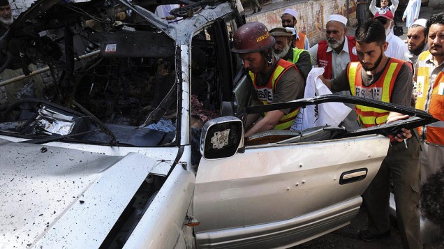 Equipes de resgate inspecionam local onde houve um ataque de carro bomba contra o veículo de um líder religioso ao lado de escola afegã, na província de Khyber-Pakhtunkhwa, no Paquistão