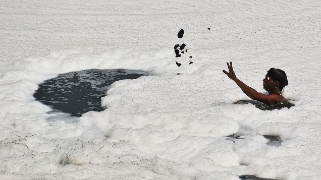 Indiano procura por moedas no leito do poluído rio Yamuna, em Nova Déli, nesta terça-feira (4), véspera do Dia Mundial do Meio Ambiente
