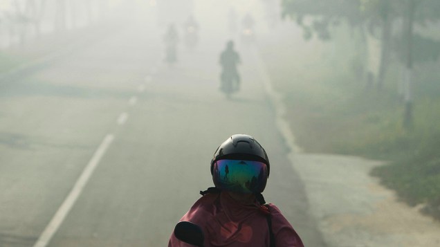 Um motorista dirige por neblina em Pekanbaru, Indonésia