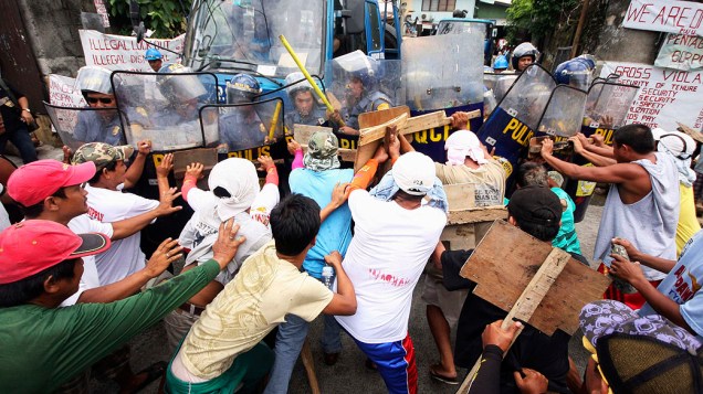 Trabalhadores demitidos de uma empresa de fabricação de aço entram em confronto com a polícia durante um comício para exigir seus empregos de volta, em Quezon City, nas Filipinas