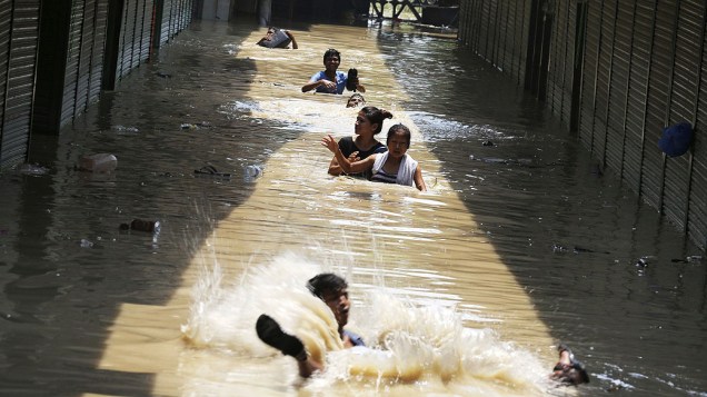 Moradores tentam por uma rua inundada situada ao longo do rio Yamuna, em Nova Delhi, Índia. Devido as fortes chuvas o número de mortes chegou a 142 e 500 desaparecidas nas últimas horas Moradores tentam por uma rua inundada situada ao longo do rio Yamuna, em Nova Delhi, Índia. Devido as fortes chuvas o número de mortes chegou a 142 e 500 desaparecidas nas últimas horas