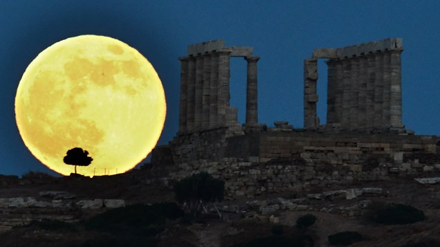 Super lua aparece ao lado do antigo templo grego de Poseidon no Cabo Sounion, ao sul de Atenas