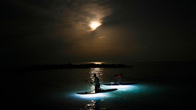 Pessoas são iluminadas pela Super Lua em suas canoas, no Canadá