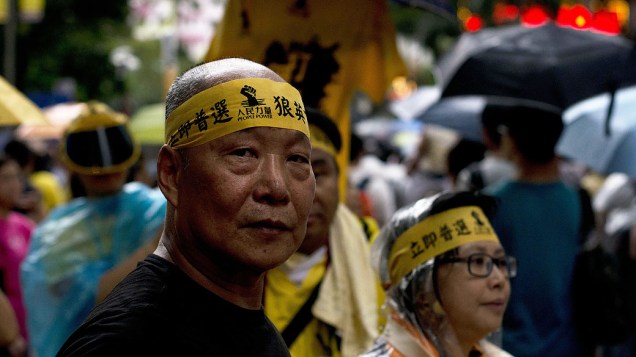 Manifestantes fazem um comício para a democracia para comemorar o 16 º aniversário da Região Administrativa Especial de Hong Kong (RAEHK). Milhares de manifestantes marcharam através de chuva gritando palavras de ordem contra o chefe executivo Leung Chun-ying e exigindo o sufrágio universal, na China
