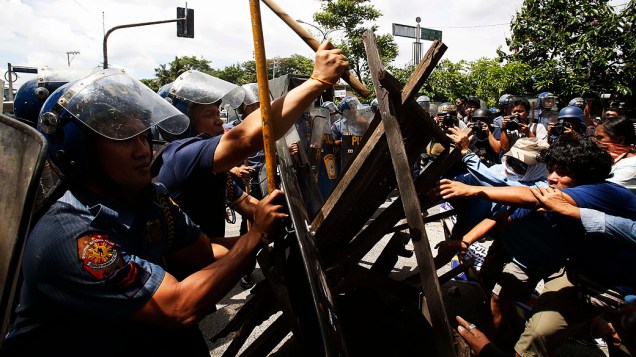 Policiais removem uma barricada criada pelos moradores durante uma dispersão na cidade de Quezon, Metro Manila 3. Dezenas de posseiros e barricadas foram colocados em uma estrada para impedir a demolição de suas casas, nas Filipinas 