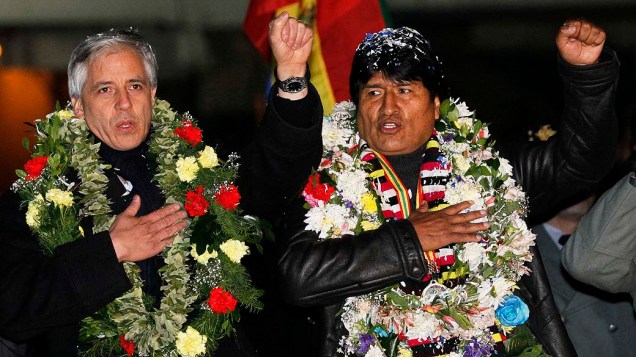 Presidente da Bolívia, Evo Morales e vice-presidente Alvaro Garcia Linera cantam o hino nacional depois de sua chegada no aeroporto de El Alto, nos arredores de La Paz, nesta quinta-feira (04). Após maratona aérea na Europa o presidente foi recebido com festa pela população