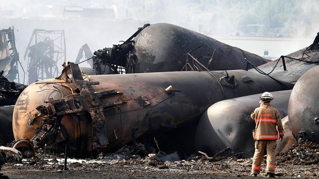 Bombeiro trabalha no local onde ocorreu o descarrilamento de trem de carga que transportava produtos derivados de petróleo e explodiu perto da cidade de Lac Megantic, Quebec, no Canadá