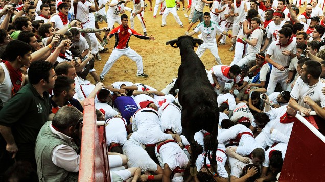 Touro pula sobre foliões em arena na tradicional festa de San Fermin, em Pamplona, no norte da Espanha
