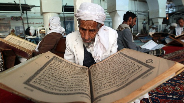 Homem iemenita lê o Corão, o livro sagrado do Islã, no primeiro dia do mês de jejum do Ramadã na Grande Mesquita, na cidade velha de , na quarta-feira (10)