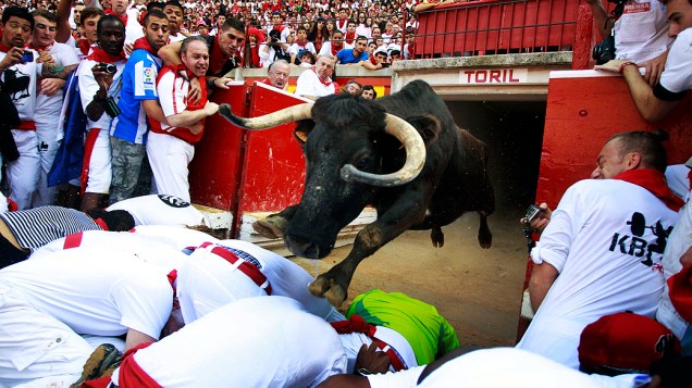 Um touro salta sobre os foliões ao entrar na arena de touros do Festival de São Firmino, em Pamplona (Espanha)