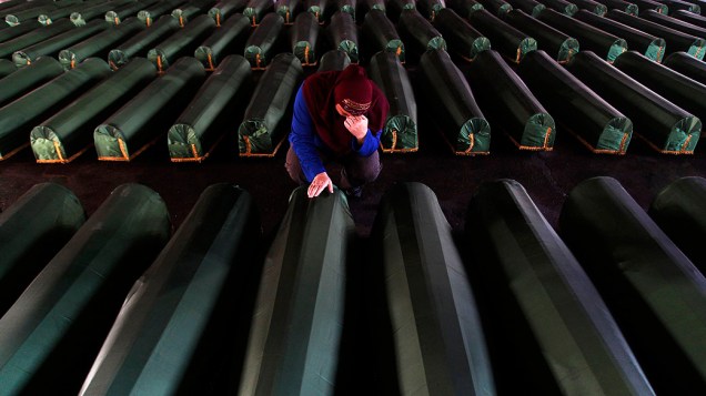 Mulher chora perto do caixão de seu parente, um dos 409 caixões de vítimas recém-identificadas do massacre de Srebrenica 1995, nesta quarta-feira (10), no Memorial Center Potocari. Os corpos das vítimas serão transportados para o centro memorial de Potocari, onde serão enterrados, marcando o 18 º aniversário do massacre em que as forças servo-bósnias comandadas por Ratko Mladic mataram cerca de 8.000 homens muçulmanos