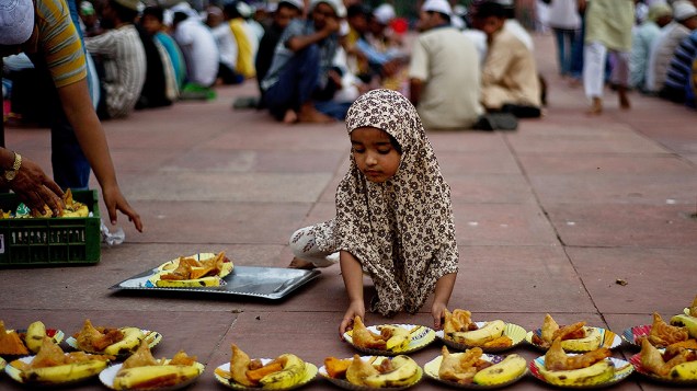 Jovem muçulmana prepara pratos de comida antes do Iftar, no primeiro dia do Ramadã, mês sagrado para os islâmicos, na mesquita de Jama Masjid, em Nova Délhi, Índia, na quinta-feira (11)