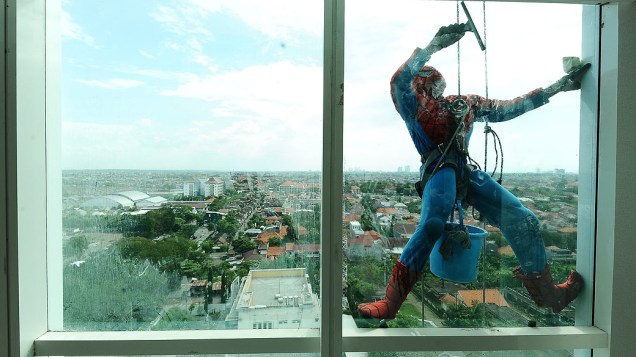 Limpador de janelas de 37 anos veste-se de Homem-aranha para limpar o vidro do Alana Hotel nesta sexta-feira (12), em Surabaya, na Indonésia