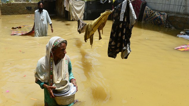 Mulher em casa inundada após chuva em Karachi, no Paquistão