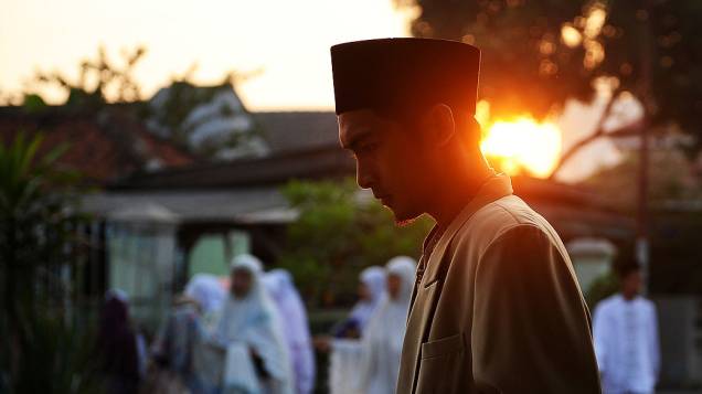 Mulçumano caminha até a mesquita para realizar as orações do Eid al-Fitr, fim do jejum do Ramadã, em Surabaya, na Indonésia
