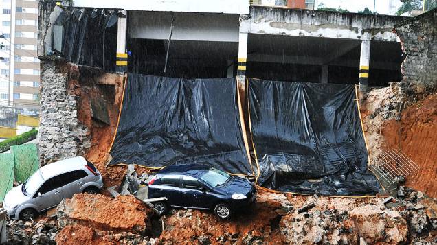 Vista de dois veículos nesta quinta-feira (08), que caíram num barranco após parte da estrutura do estacionamento de um prédio de oito andares desabar em Salvador (BA), no Bairro de Brotas