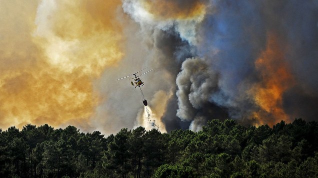 Helicóptero trabalha para controlar um incêndio florestal, perto de Penalva do Castelo, em Portugal