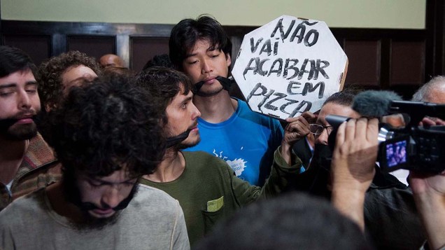 Jovens que ocupam a Câmara Municipal do Rio de Janeiro ficam "amordaçados" enquanto acompanham a primeira sessão da CPI dos Ônibus, nesta quinta-feira (15)