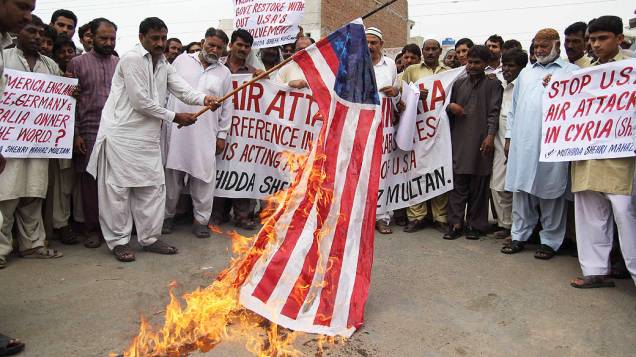 Manifestantes pertencentes do Estado da Ação Cidadã (UCA)  queimam a bandeira dos Estados Unidos durante um protesto contra um possível ataque dos Estados Unidos à Síria, em resposta à alegada utilização de armas químicas pelo governo de Bashar al-Assad, em Multan, no Paquistão