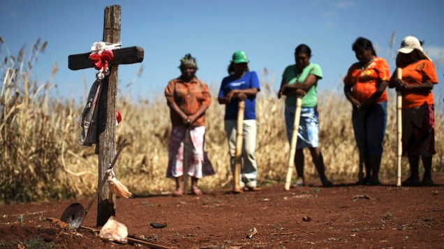 Índios Guarani Kaiowa em frente ao túmulo de um índio de 15 anos, morto por um fazendeiro, no conflito por terras no Mato Grosso do Sul