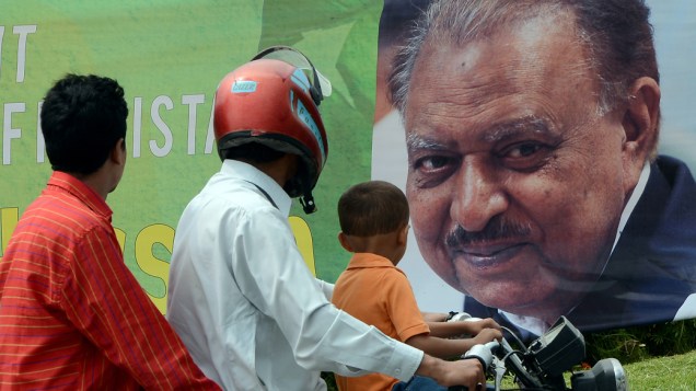 Paquistaneses passam por banner com a imagem do presidente recém-eleito, Mamnoon Hussain, em Islamabad