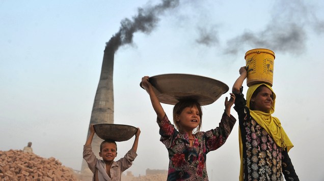 Crianças afegãs carregam carvão de fábrica de tijolos para suas casas, nesta terça-feira (10)