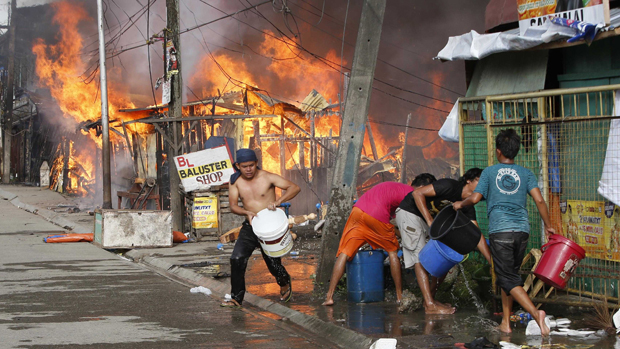 Moradores tentam apagar incêndio após confronto entre soldados do governo e rebeldes muçulmanos da Frente Moro de Libertação Nacional (FMLN) na cidade de Zamboanga, no sul da Filipinas