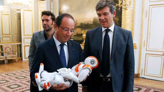 O presidente da França, François Hollande observa um robô humanóide durante visita a uma exposição sobre design industrial e tecnologia no Palácio Eliseu, em Paris, nesta quinta-feira (12)