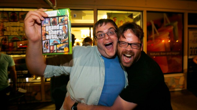 Jogador comemora o lançamento do game "GTA V" com Michael Petterson, um dos desenvolvedores do jogo em uma loja de jogos em Encinitas, Califórnia