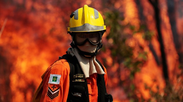 Bombeiro trabalha para tentar extinguir as chamas de um incêndio florestal na área de conservação ambiental perto Palácio Jaburu, residência oficial da vice-presidência, em Brasília