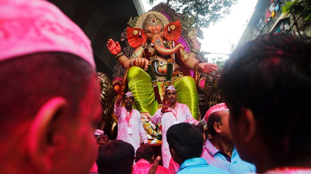 Devotos carregam um ídolo do deus hindu Ganesh, divindade da prosperidade, durante uma procissão pelas ruas, no último dia do festival Ganesh Chaturthi, em Mumbai, na Índia