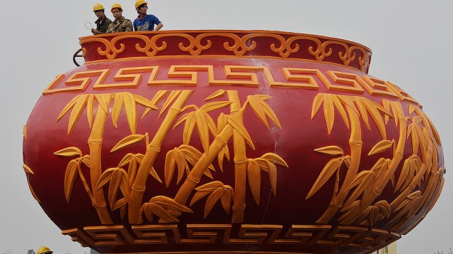 Trabalhadores instalam um vaso gigante para a comemoração do Dia Nacional da China na Praça Tiananmen, em Pequim