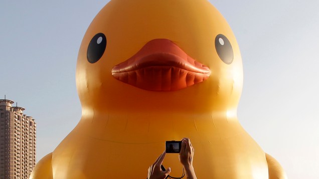 Um homem tira foto do "Rubber Duck", um pato de borracha gigante do artista holandês Florentijn Hofman, em exibição no Porto de Kaohsiung, no sul de Taiwan