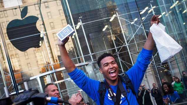 Um dos primeiros clientes a comprar o iPhone 5S da Apple comemora após sair da loja na Quinta Avenida, em Manhattan, Nova York