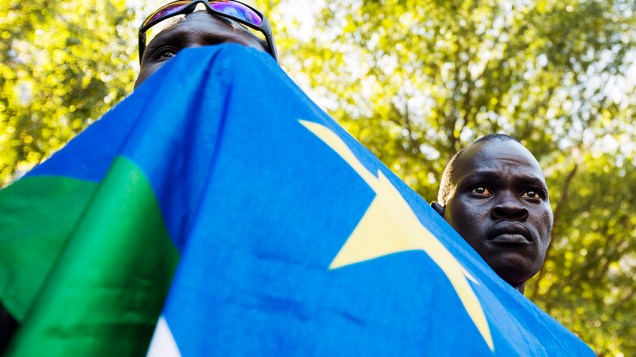 Homens seguram a bandeira do Sudão do Sul do lado de fora da sede da ONU em Nova York pedindo um referendo sobre a independência da região de Abyei disputada entre o Sudão e o Sudão do Sul