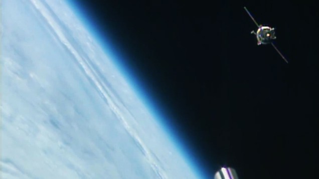 Imagem capturada pela Nasa TV mostra a cápsula Soyuz, que leva três astronautas até a Estação Espacial Internacional, nesta quinta-feira (26)