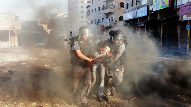 Policiais de fronteira israelenses detém um manifestante palestino durante confrontos no campo de refugiados de Shuafat na Cisjordânia, perto de Jerusalém