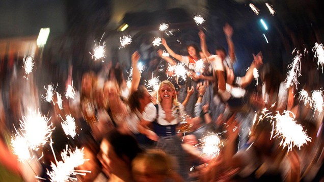 Garçonetes dançam nas mesas  enquanto celebram o fim do maior festival de cerveja do mundo, a Oktoberfest, em Munique, Alemanha