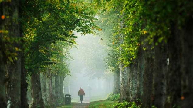 Mulher caminha através da névoa em Arundel, um burgo ao redor de um castelo no sul da Inglaterra