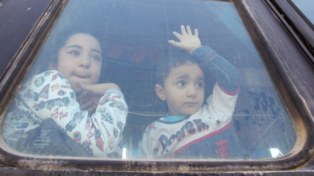 Crianças palestinas esperam para cruzar fronteira para o Egito, reaberta parcialmente para pacientes que procuram tratamento e para alunos que estudam fora de Gaza