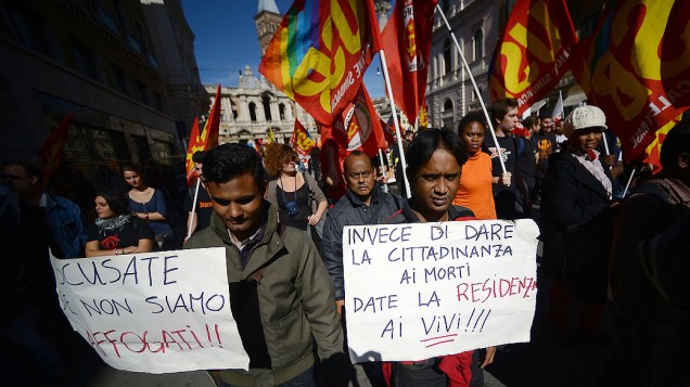 Imigrantes seguram cartazes dizendo Em vez de dar cidadania aos mortos, dar-lhe a vida!, durante um protesto contra as medidas de austeridade, em Roma, na Itália