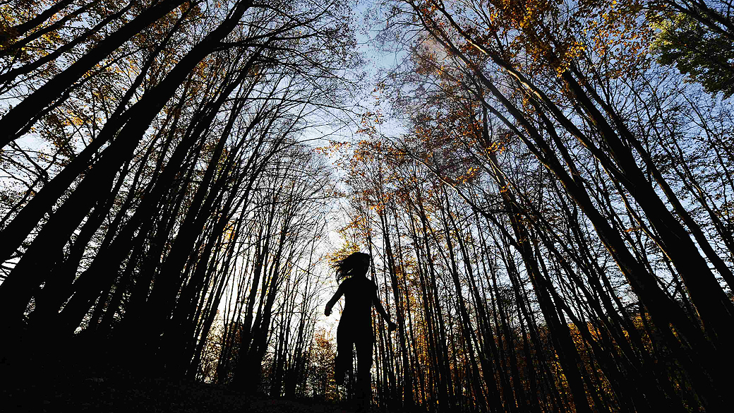 Menina anda através de um bosque na aldeia de Mavrovo, na Macedônia