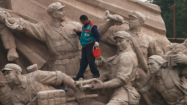 Trabalhador anda em um monumento durante trabalhos de manutenção na Praça da Paz Celestial, em Pequim, na China