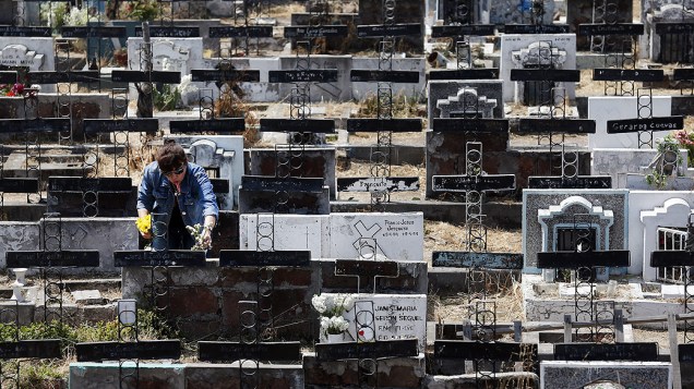 Mulher visita um túmulo no Cemitério Metropolitano de Santiago, no Chile durante Dia de Finados