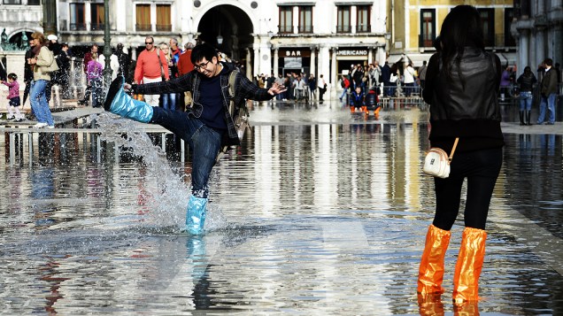 Turistas na praça de São Marcos no período da Acqua Alta, em Veneza, nesta segunda-feira (4)