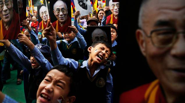 Estudantes tibetanos seguram imagens do líder espiritual Dalai Lama e de Mahatma Gandhi durante um protesto em Nova Déli, na Índia,  nesta quarta-feira (06)