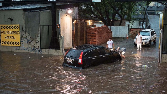 Carro atravessa rua inundada para chegar em um hospital na Avenida João Pessoa em Porto Alegre (RS)